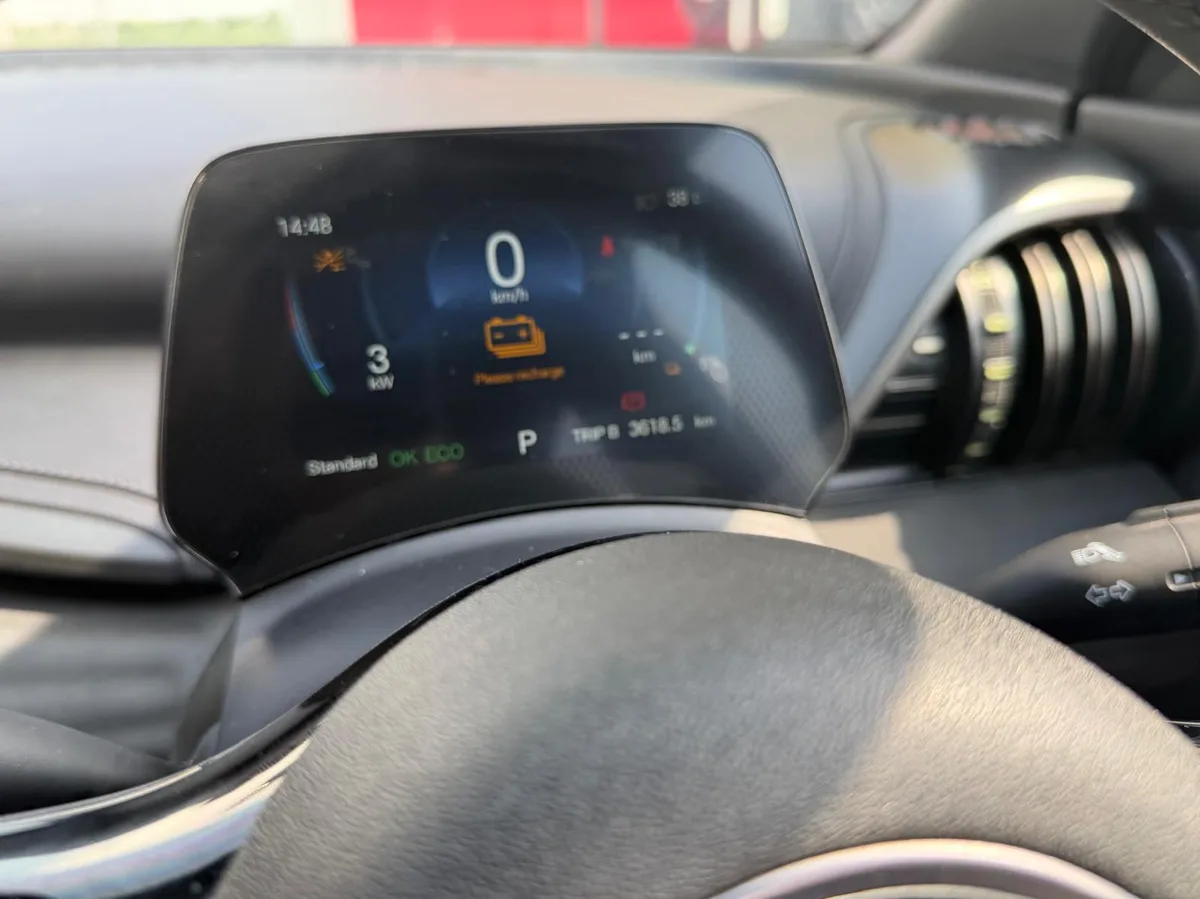 The instrument cluster showing a Please recharge warning at 5% battery