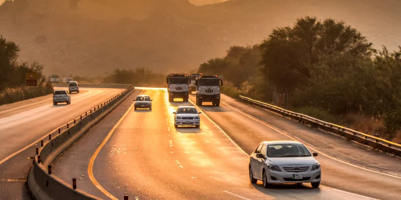 Cars driving on the M-2 motorway at sunset with the Salt Range hills in the background