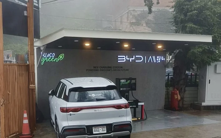 A BYD Atto 2 charging at a mountain station in the rain in northern Pakistan
