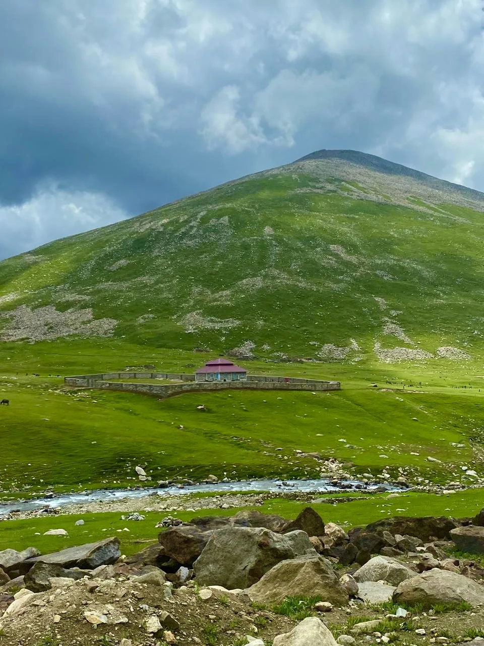 Green meadows, a mountain stream and a lone hut on the climb toward Babusar Top