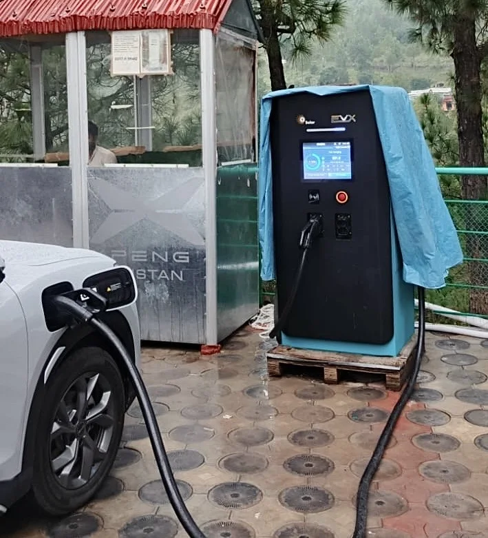 The Atto 2 plugged into a DC charger in the rain at Murree, on the climb into the hills